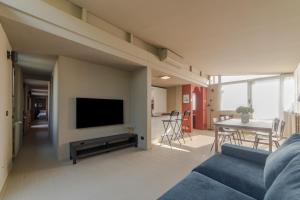 Home 12 في ميلانو: غرفة معيشة مع أريكة زرقاء وتلفزيون