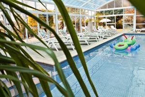 a pool with chaise lounges and a swimming pool with a swimming pool at Hotel Doña Jimena in Villarcayo