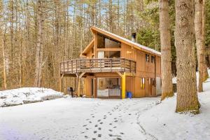 a house in the woods with footprints in the snow at Dwight Road Getaway in Quechee