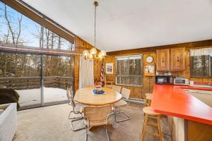 a kitchen and dining room with a table and chairs at Dwight Road Getaway in Quechee