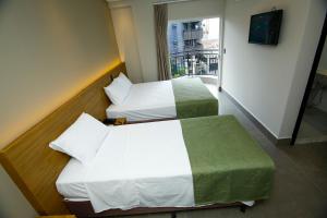 una camera d'albergo con due letti e una finestra di NEO PARK HOTEL a Maringá