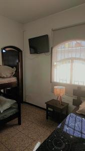 a bedroom with a bed and a tv on the wall at Pousada Litoral Norte Caragua in Caraguatatuba