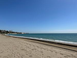 une plage avec des empreintes sur le sable et l'océan dans l'établissement APARTAMENTOS LA CALA de MIJAS, à La Cala de Mijas