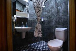 La salle de bains est pourvue de toilettes, d'un lavabo et d'un rideau de douche. dans l'établissement Otel konforunda sıte ıcı guvenlıklı studyo daıre, à Istanbul