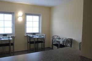 a room with two tables and chairs and two windows at Hotel Pension Schwerin-Haus Schreiber in Schwerin