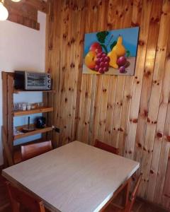une table dans une pièce avec une photo de fruits sur le mur dans l'établissement Departamento Luminoso, à Montecarlo