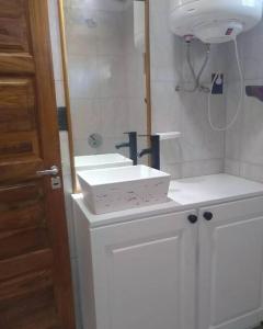 La salle de bains est pourvue de 2 lavabos blancs et d'un miroir. dans l'établissement Departamento Luminoso, à Montecarlo