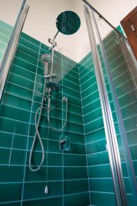y baño con ducha de azulejos azules. en Villa Ara, en Torre delle Stelle