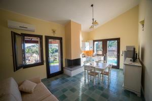 a living room with a couch and a table and a kitchen at Villa Ara in Torre delle Stelle +13 photos