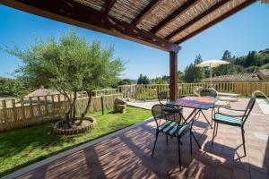 un patio con mesa, sillas y un árbol en Villa Ara, en Torre delle Stelle