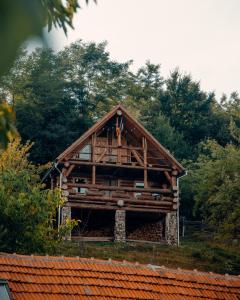 a large wooden house with trees in the background at Heaven Treehouse - ADULT ONLY RESORT, SELF CHECK IN in Peşteana