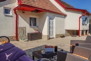 a patio with a couch and chairs and a house at Lily's House in Cisnădie