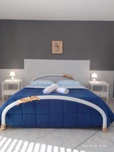 a bedroom with a blue bed with two white tables at Sea life Terrasini in Terrasini