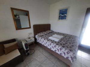 a small bedroom with a bed and a mirror at TIZA Apartments in Vantačići