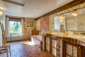 a large bathroom with two sinks and a tub and a tubermott at La Fauconnerie Du Roy in Montainville