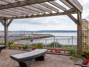 a bench on a patio with a view of a marina at Puffling in Poole