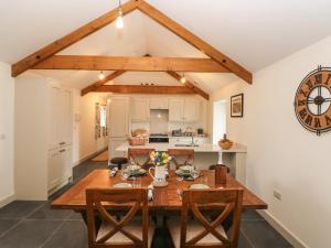 a kitchen and dining room with a wooden table and chairs at The Byre in Bridgend