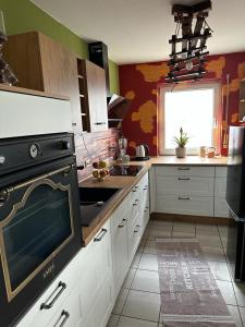La cuisine est équipée de placards blancs et d'un four avec plaques de cuisson noires. dans l'établissement Wohnung Emilia, à Mörfelden-Walldorf