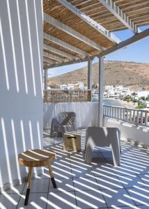 eine Terrasse mit Stühlen und einem Tisch auf dem Dach in der Unterkunft Cactus Suites Kythnos in Mérikhas