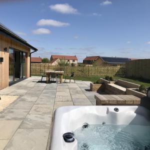 a bath tub sitting on top of a patio at Dragonfly Cottage, Ashlin Farm Barns in Lincoln