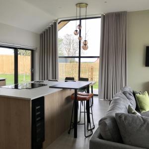 a kitchen and living room with a table and a couch at Dragonfly Cottage, Ashlin Farm Barns in Lincoln