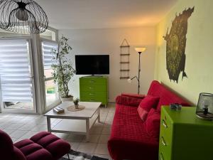 ein Wohnzimmer mit einem roten Sofa und einem TV in der Unterkunft Wohnung Emilia in Mörfelden-Walldorf