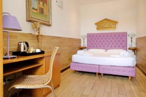 sypialnia z fioletowym łóżkiem i biurkiem w obiekcie Sonnino Suite w Rzymie