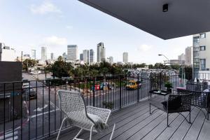 einen Balkon mit Stühlen und Stadtblick in der Unterkunft Gorgeous 3 bedrooms, Parking , New building in Tel Aviv