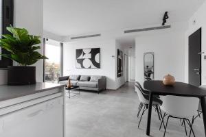 uma cozinha e uma sala de estar com mesa e cadeiras em Gorgeous 3 bedrooms, Parking , New building em Tel Aviv