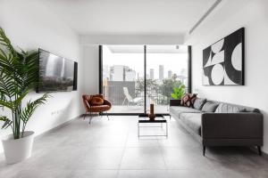 uma sala de estar com um sofá e uma cadeira em Gorgeous 3 bedrooms, Parking , New building em Tel Aviv