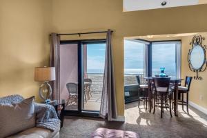 a living room with a table and a view of the ocean at Palm Beach Club 3-235 in Pensacola Beach