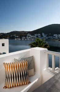 a white bench with two pillows sitting on a balcony at Cactus Suites Kythnos in Mérikhas