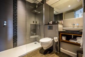 a bathroom with a toilet a sink and a shower at The Alexander Pope Hotel in Twickenham