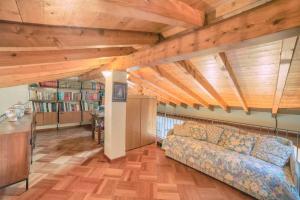 una sala de estar con sofá y techos de madera. en Villa Gaia en Stresa