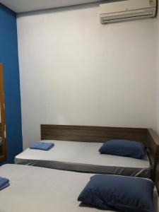 a bedroom with two beds with blue pillows at Hotel Florêncio in Sao Paulo