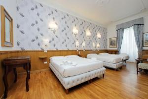 pokój hotelowy z 2 łóżkami i stołem w obiekcie Sonnino Suite w Rzymie