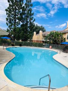 a large blue swimming pool at a resort at Stylish 2 bedroom near Ontario Airport in Fontana