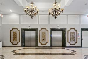 eine Lobby mit Aufzügen und Kronleuchtern in der Unterkunft Wyndham Garden Baronne Plaza in New Orleans