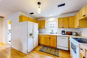 a kitchen with wooden cabinets and a white refrigerator at West Asheville Loft in Asheville