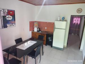 uma pequena cozinha com uma mesa e um frigorífico em Miguel Departamentos 2 em Puerto Iguazú