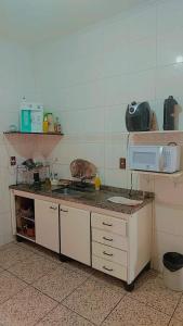 a kitchen with a counter with a microwave on it at Pousada Litoral Norte Caragua in Caraguatatuba