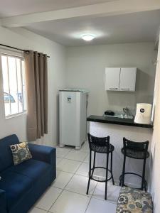 sala de estar con sofá y cocina con nevera. en Apartamento Premium Grand Luxo, en Fortaleza