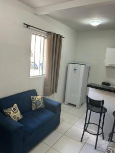 a living room with a blue couch and a kitchen at Apartamento Premium Grand Luxo in Fortaleza