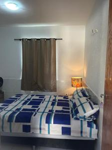 a bedroom with a blue and white bed and a window at Apartamento Premium Grand Luxo in Fortaleza