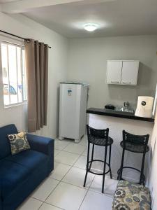 a living room with a blue couch and a kitchen at Apartamento Premium Grand Luxo in Fortaleza