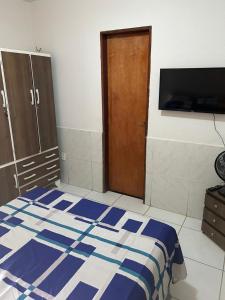 a bedroom with a blue and white bed and a wooden door at Apartamento Premium Grand Luxo in Fortaleza