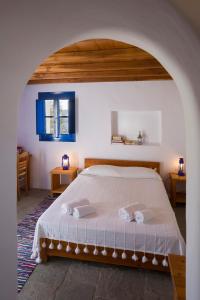 a bedroom with a bed and two tables at Marketos Windmill and Houses in Tripití