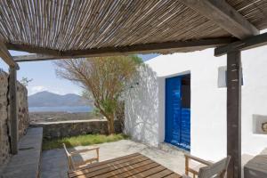 a patio with a blue door and two chairs at Marketos Windmill and Houses in Tripití