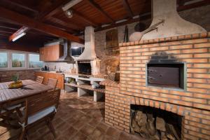 uma sala de estar com uma lareira de tijolos numa cozinha em Quinta dos Silvas - Piscina em Ancião