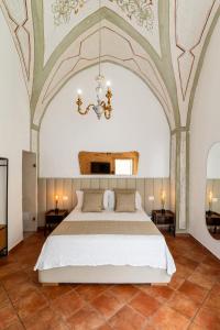 a bedroom with a large bed and a chandelier at B&B Corte Patitari in Gallipoli